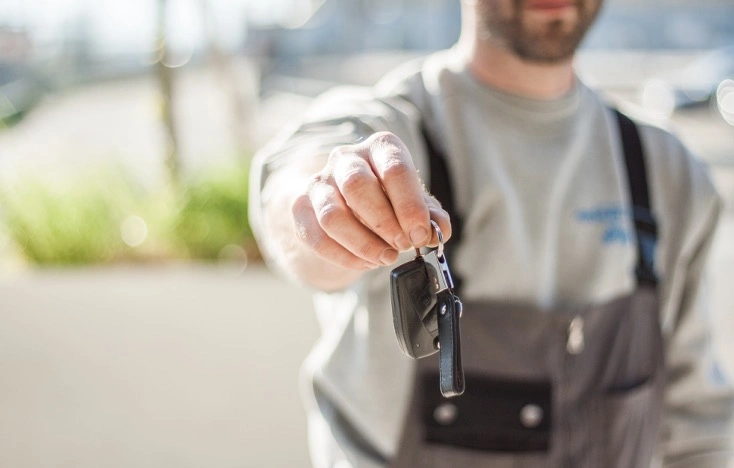 Car rental service with keys being handed to customer